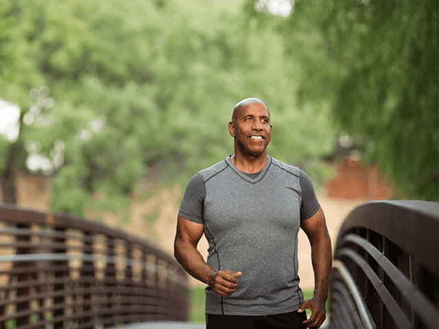 Man smiling on a bridge.