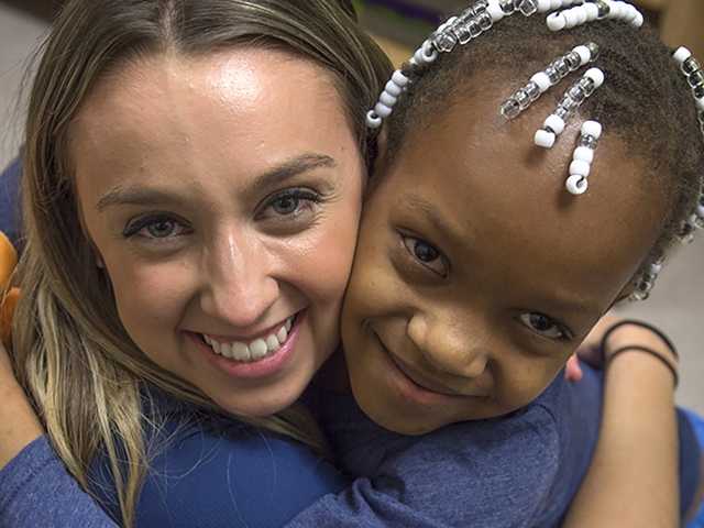 Smiling woman and child hug each other