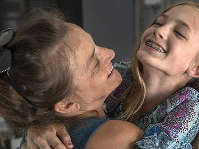 Woman hugging child.