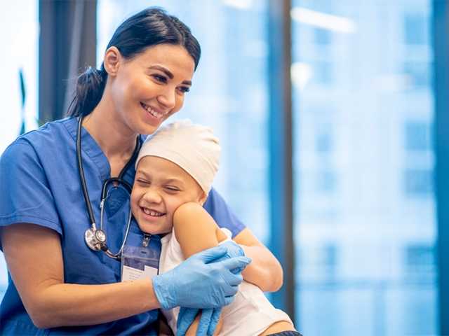 Healthcare provider hugging child.