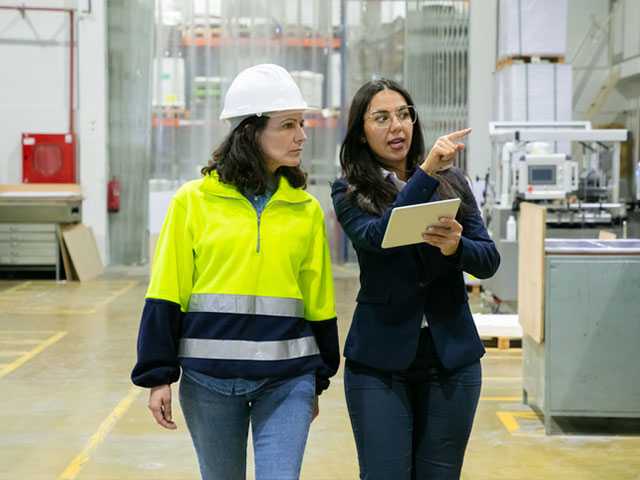 Two women walking through warehouse