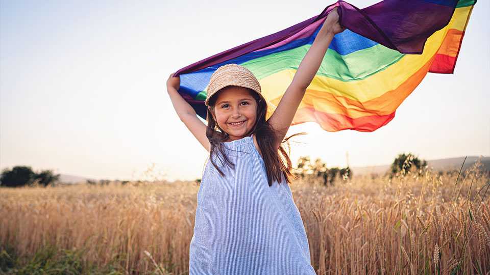 Two woman holding rainbow flag.