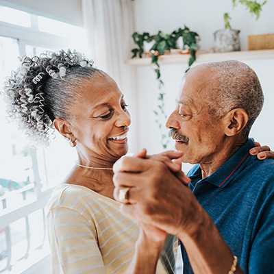 happy older couple dancing at home